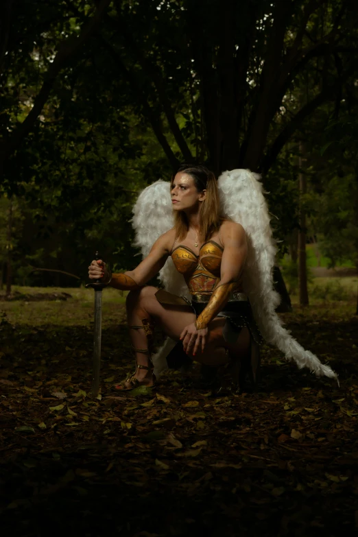 the girl is wearing a costume with wings and holding a sword