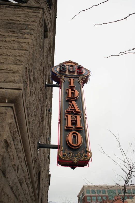 a neon sign is hanging from a building