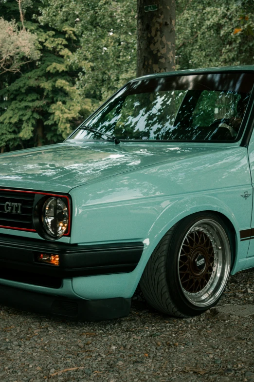 a blue and black car is parked in the woods