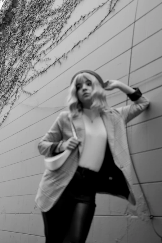 a woman leaning against a wall while leaning on the side