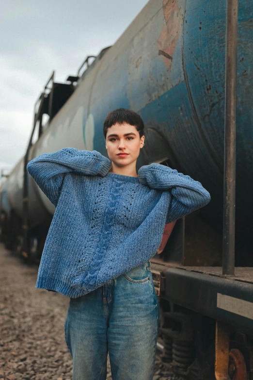 boy standing on side of train with his hand on his shoulder