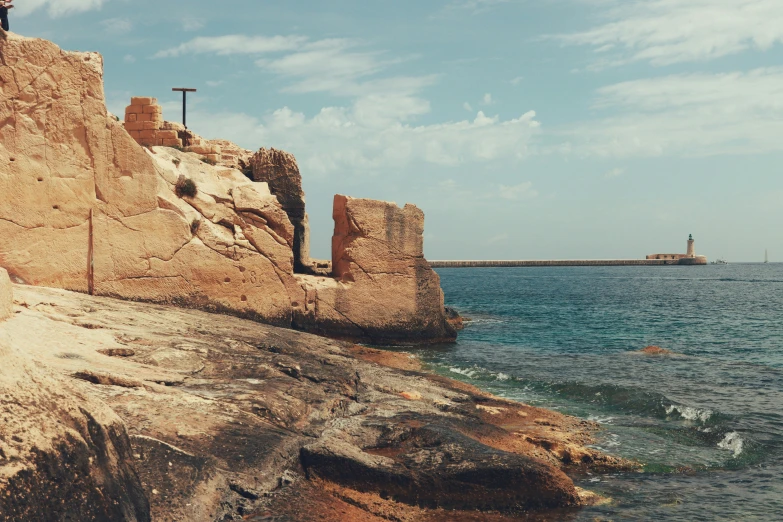 a beach with water and large rocks on the ground