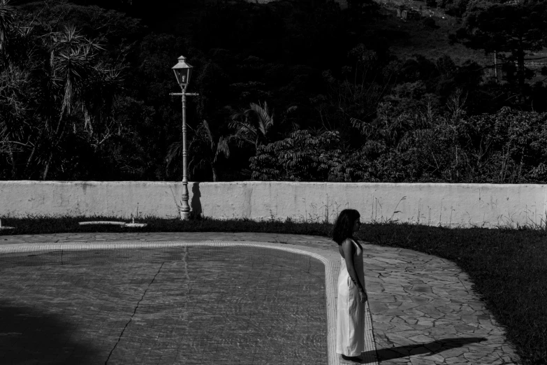 a woman walking away from a bench next to a wall