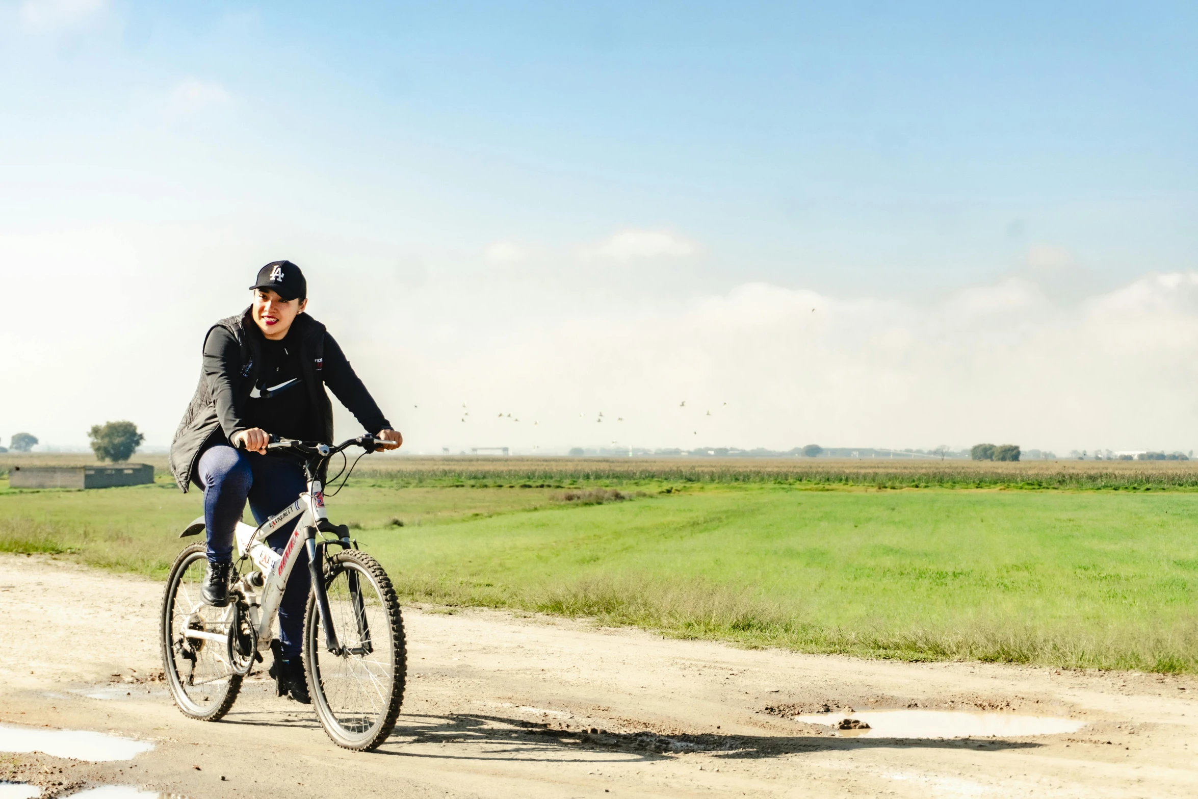 a young man riding a bike down a rural road