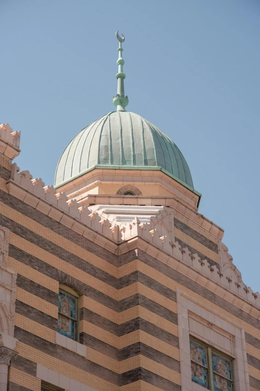 the top portion of a building with a domed green roof