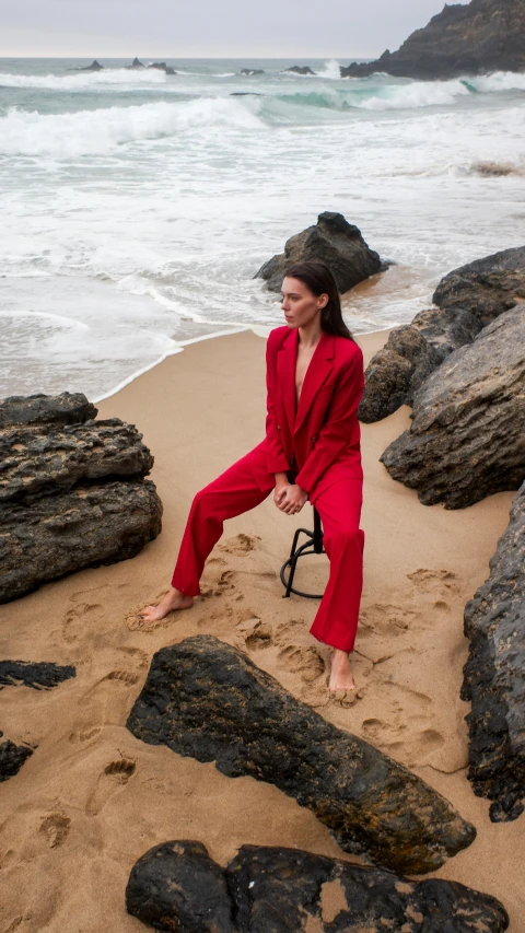 a woman in red in a red suit on a beach