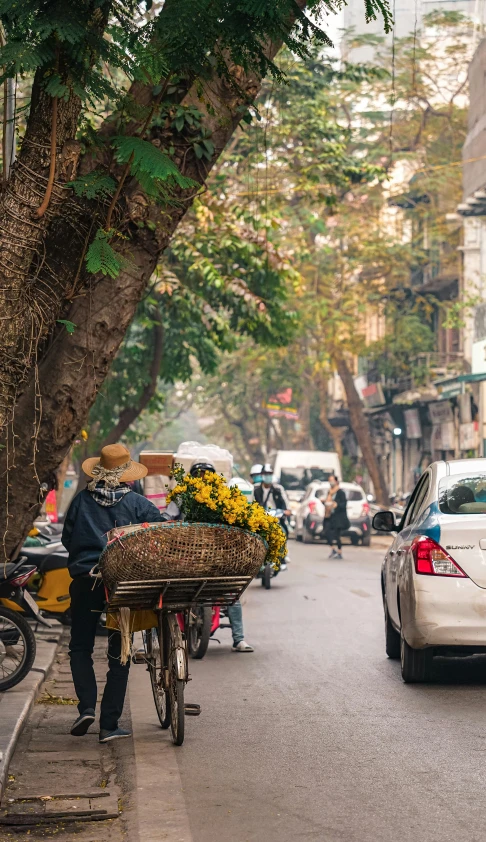 a man standing on a street holding a basket full of flowers