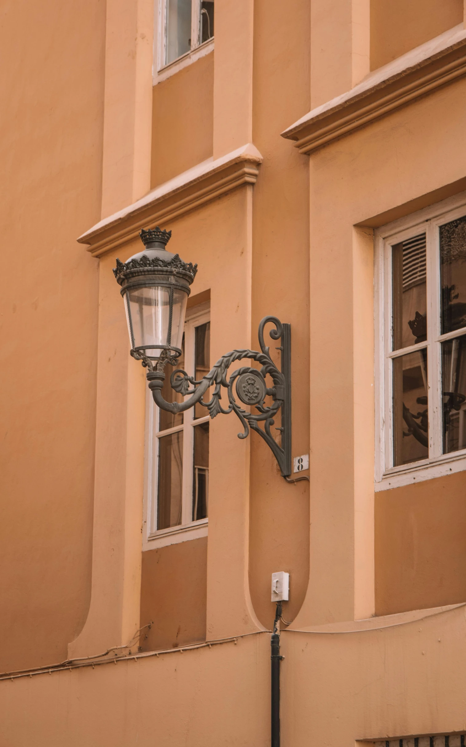 an old fashioned street light mounted to the side of a building
