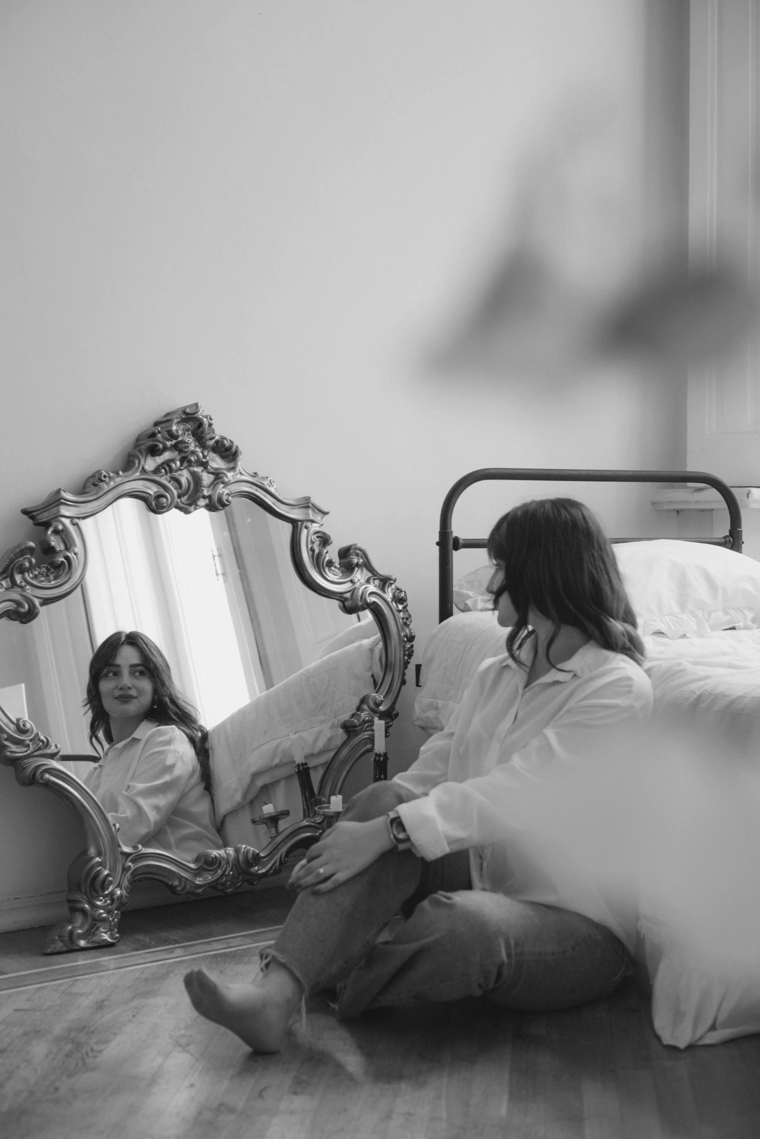 a woman sitting on the floor in front of a mirror