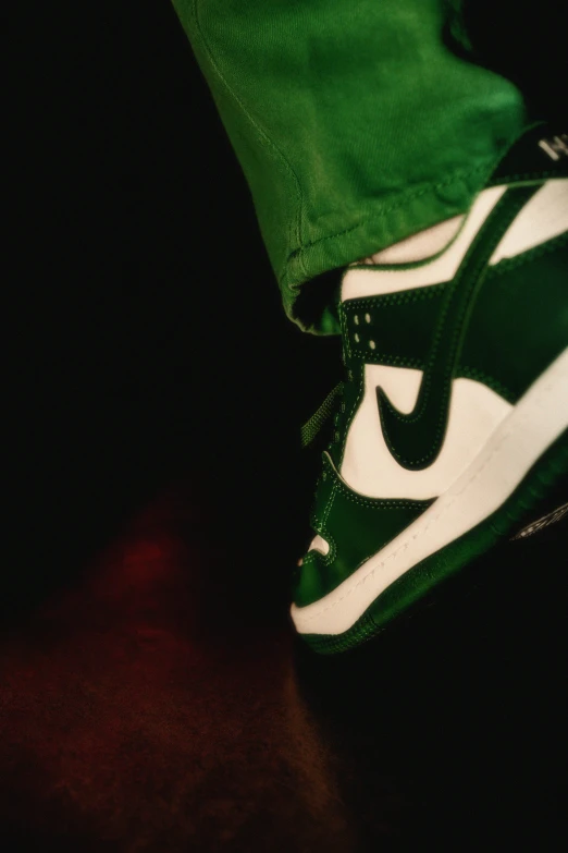 this shoe is green and white with a black stripe