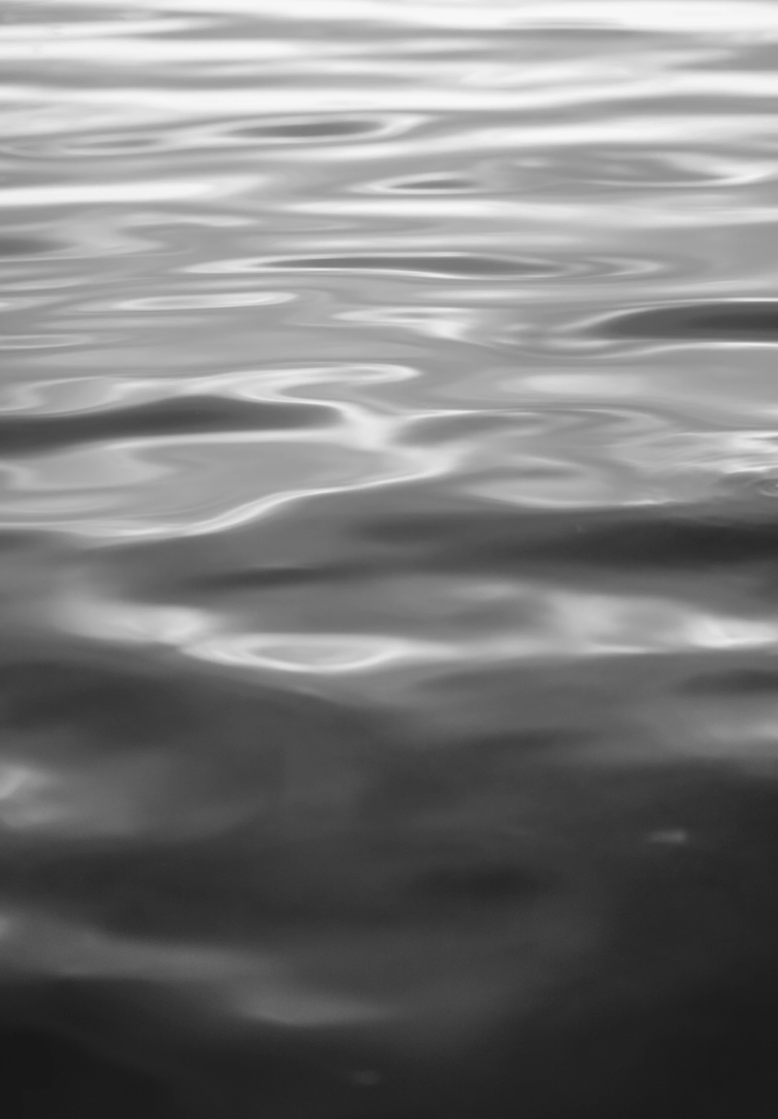 an abstract black and white po of waves on the water