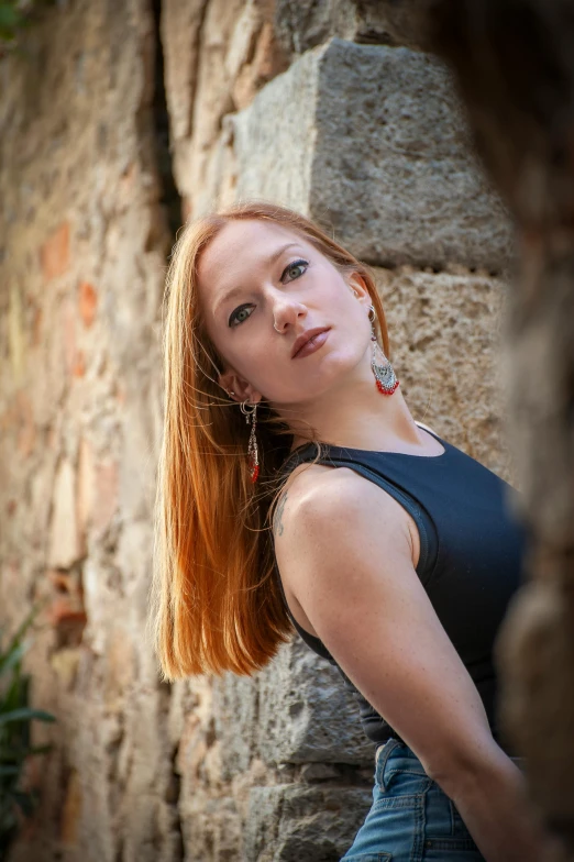 red haired woman in black shirt by wall