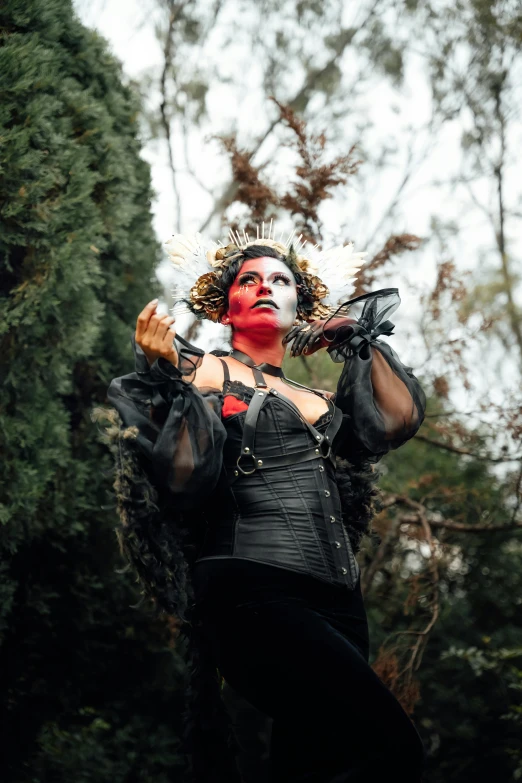 a person in black and white makeup with a tree background