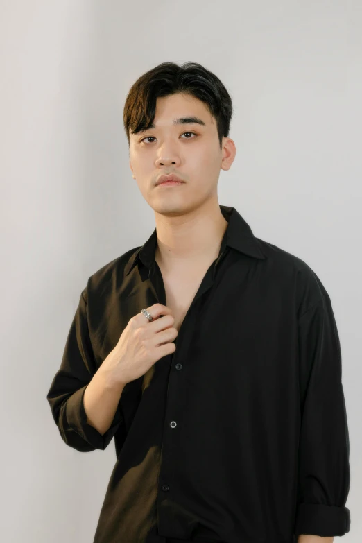man in black shirt with left hand under his chest