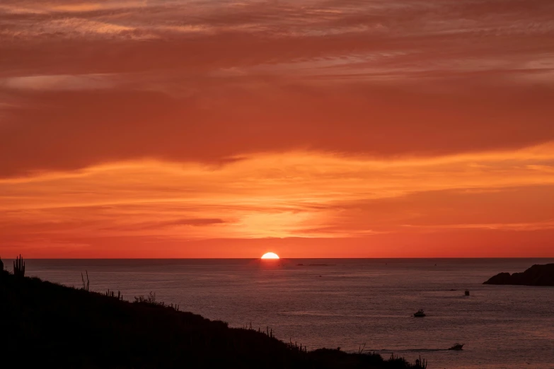 a sunset over water with an orange sky