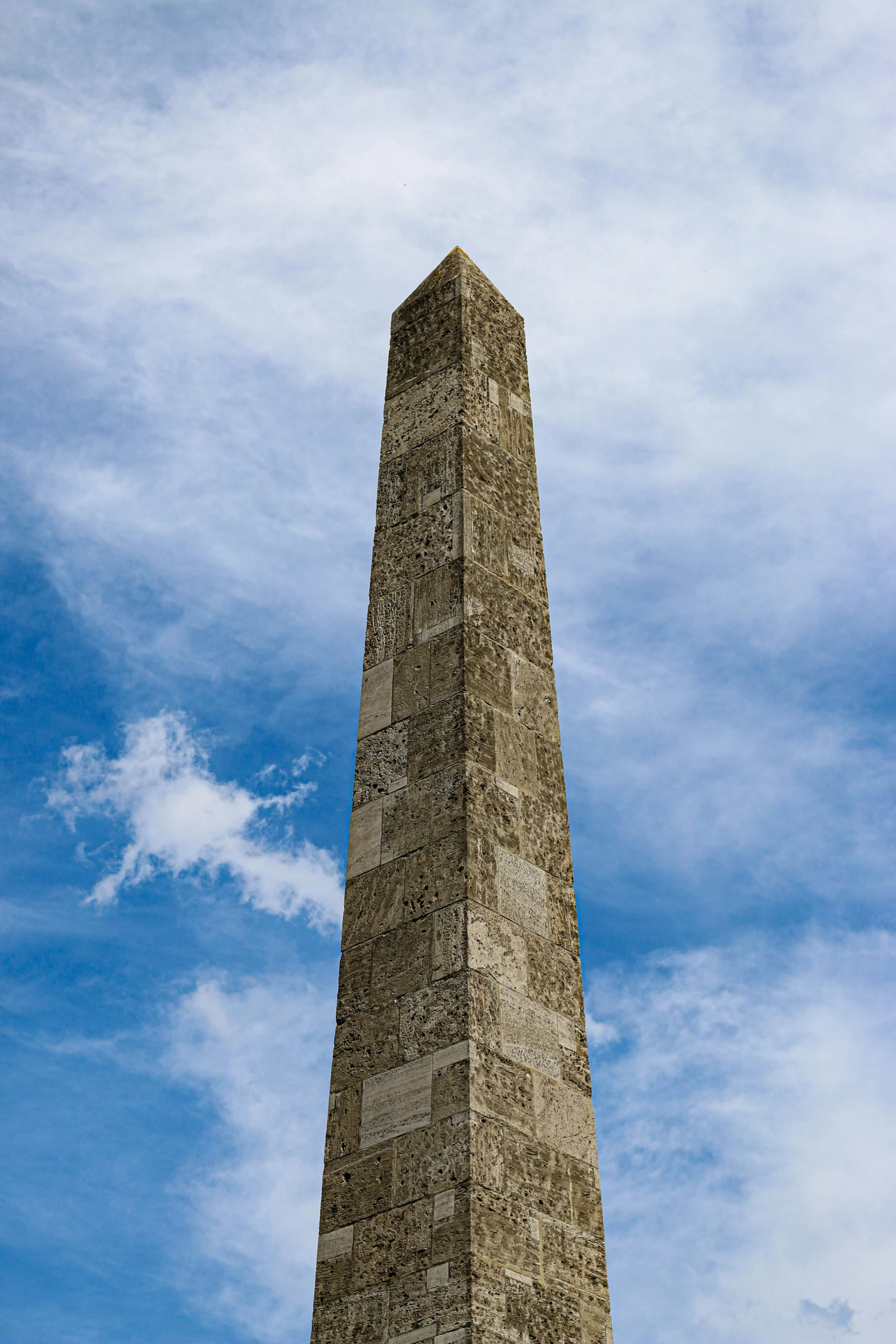 a tower with an arrow on it is in the sky