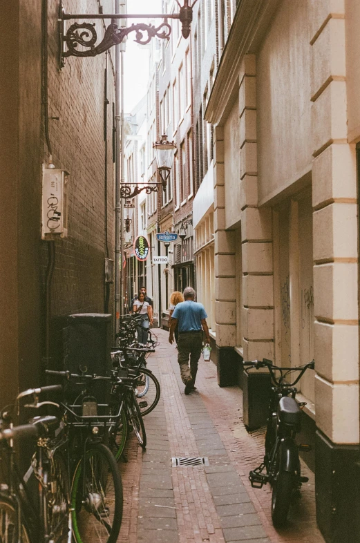 a man walks down the narrow city street