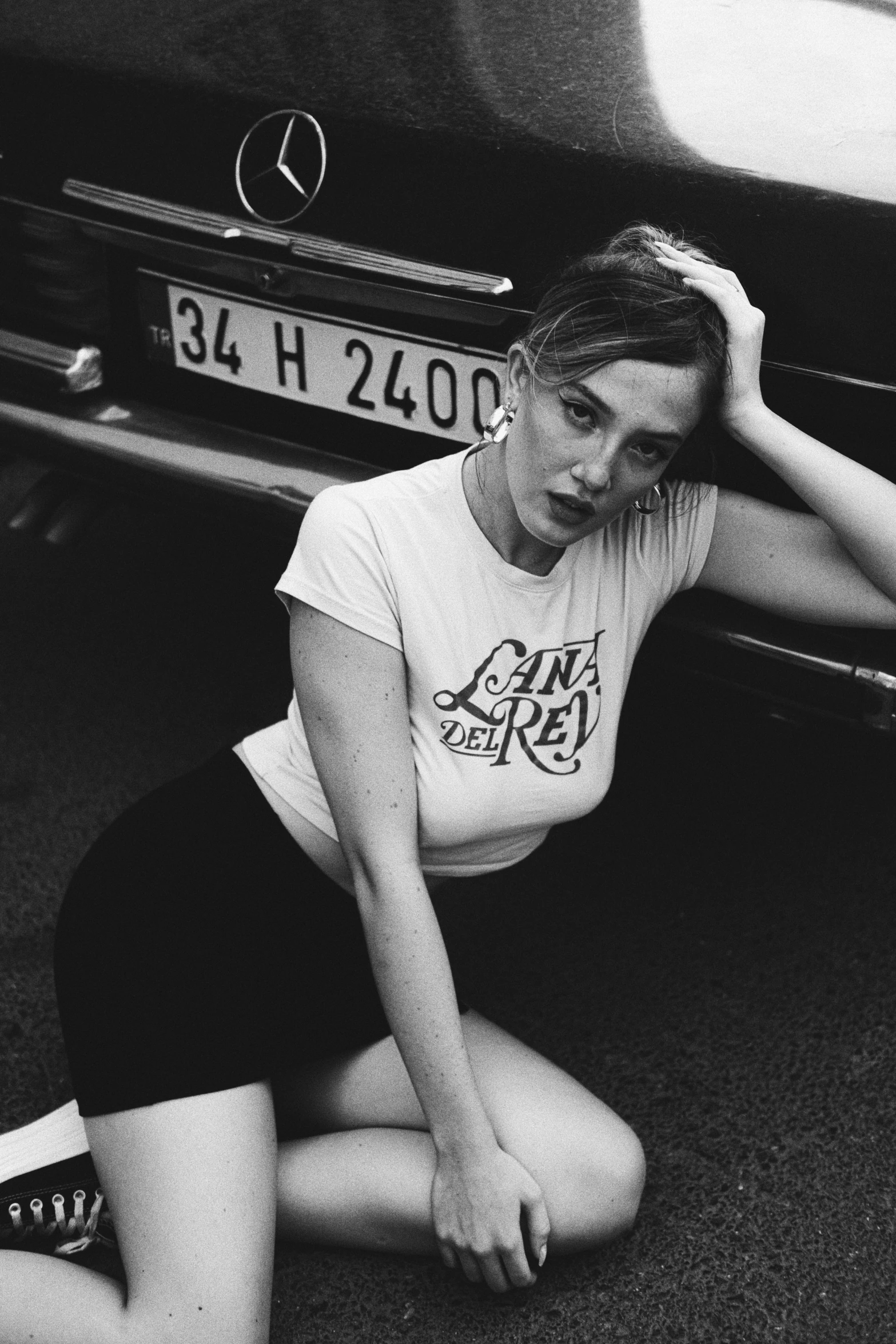 a girl sitting in front of a car