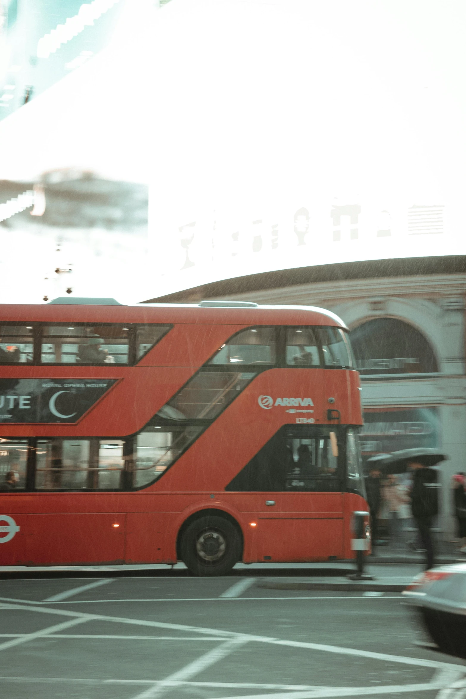 a red double decker bus driving down the street