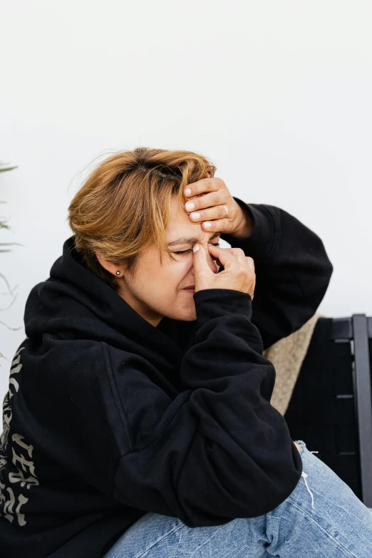 a woman sitting down and looking at her cell phone