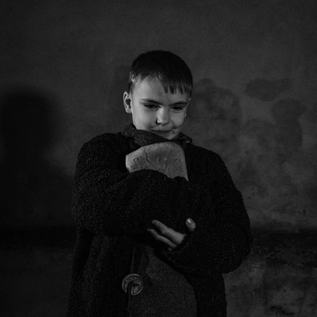 a black and white po of a boy holding a teddy bear