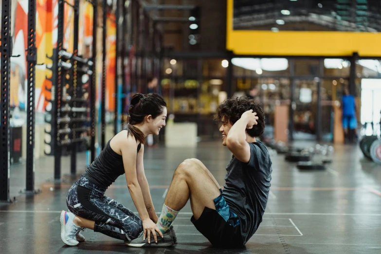 two young people sitting down on the floor and staring at each other