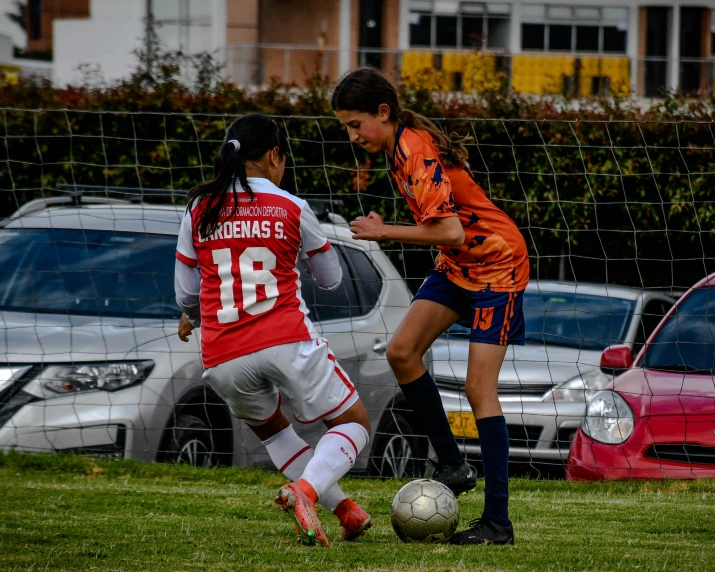 two soccer players fight for the ball in front of the goal