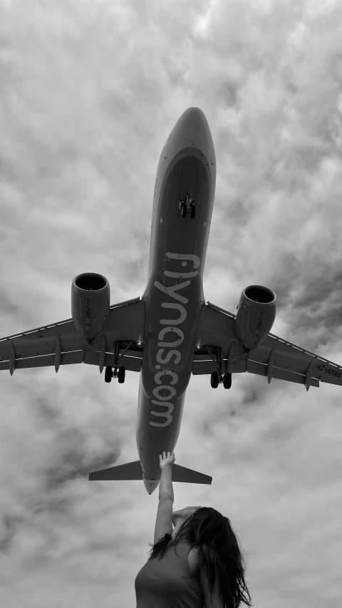 a woman in black shirt reaching into an airplane