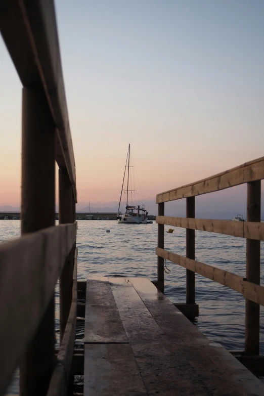 the sun is setting on the calm water by the boats