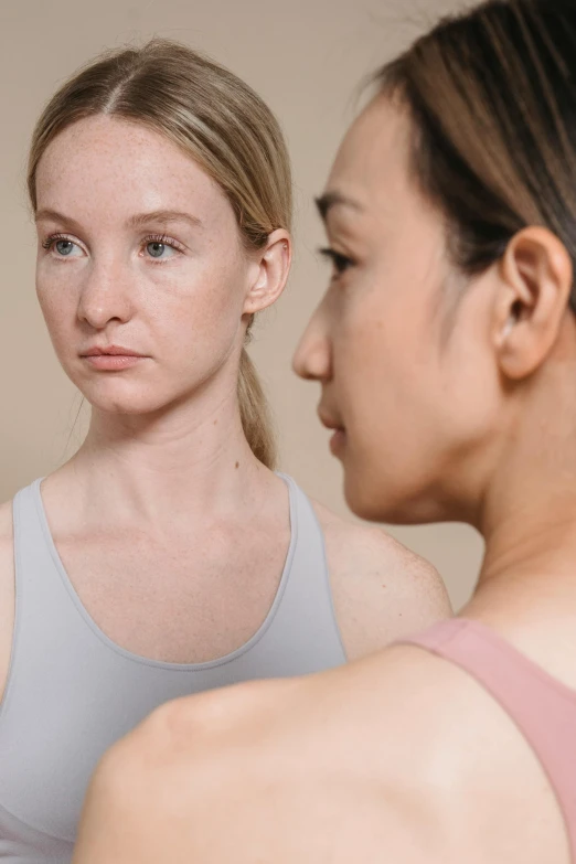 two young women staring at each other as they do not know what