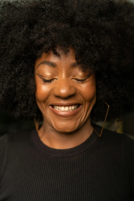 a woman smiling with large black hair