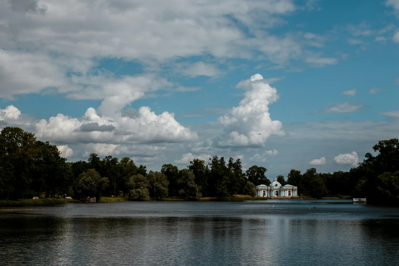 a pond filled with water under a cloudy blue sky