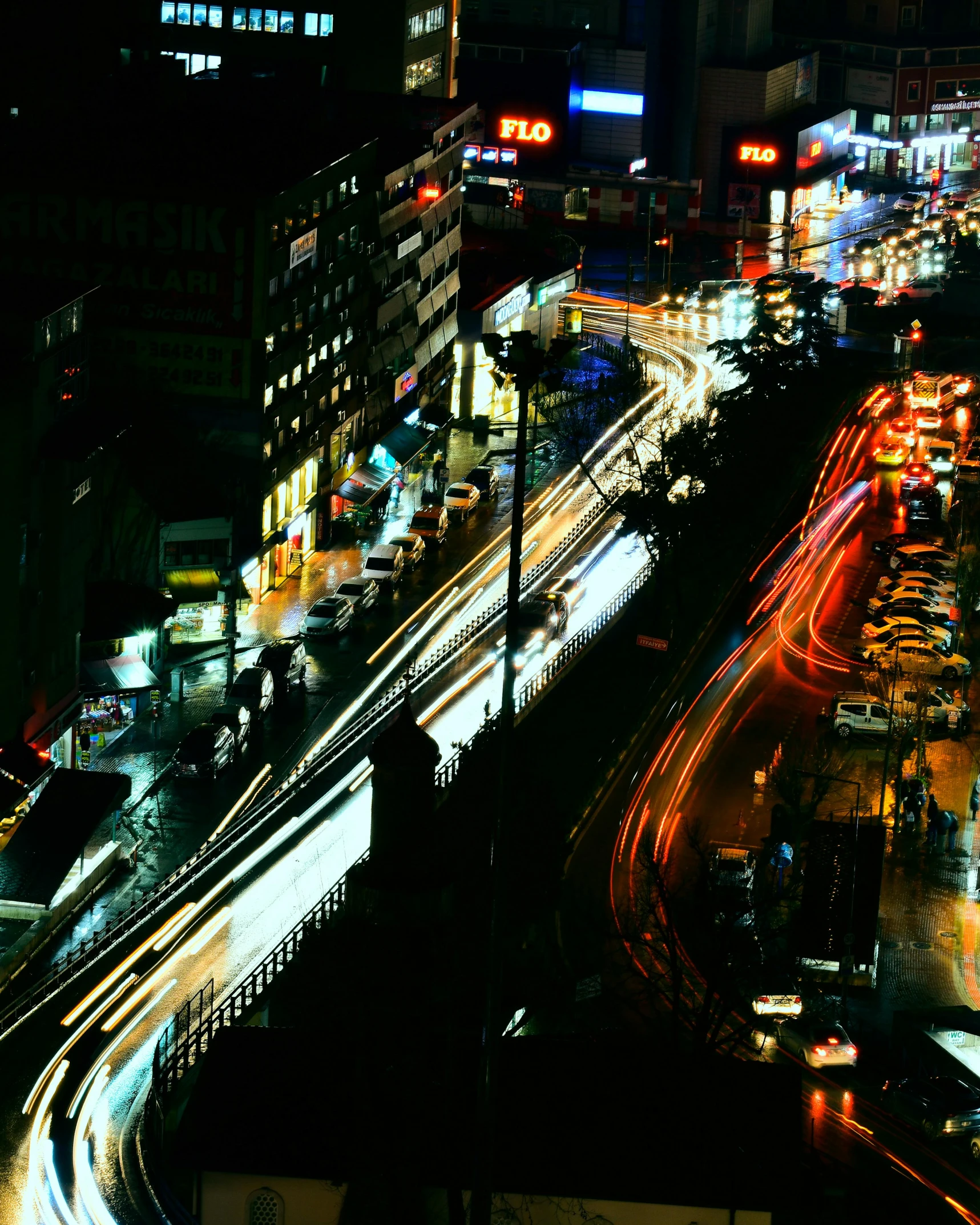 a city at night has traffic and light trails in the street