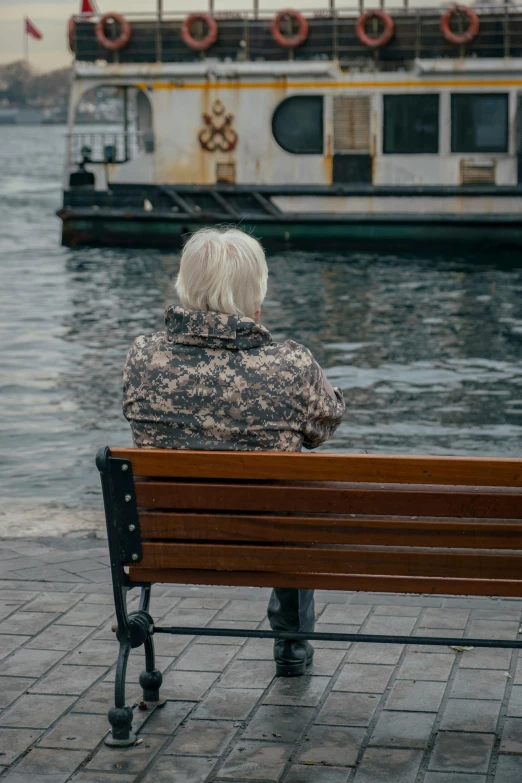 woman sitting on a park bench near a lake