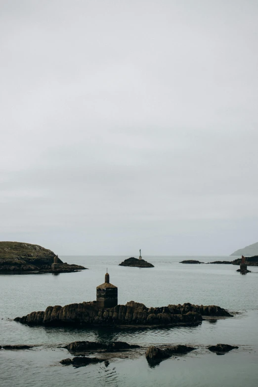 a lighthouse sits on an island in the middle of water