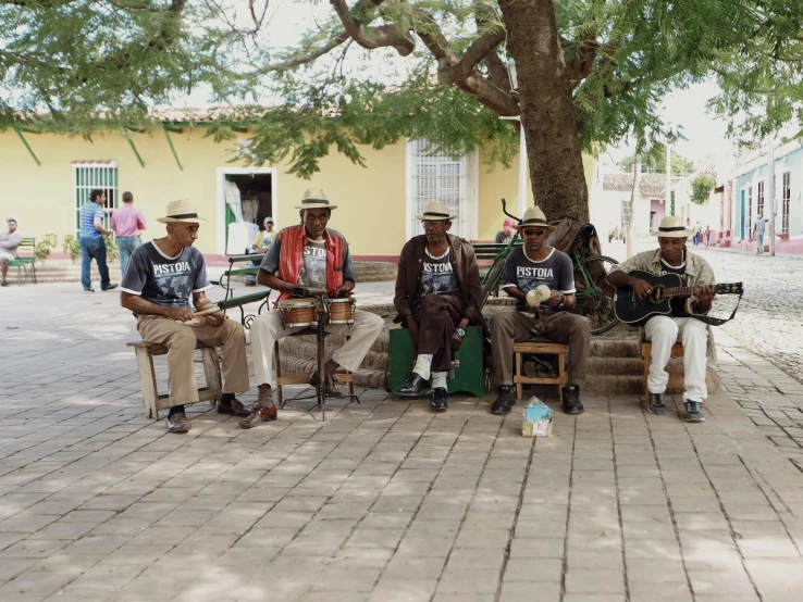 some men are sitting on a bench outside