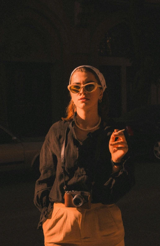 a woman wearing glasses and a head scarf smoking a cigarette