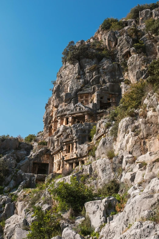 the ruins are made out of rock on the side of the hill