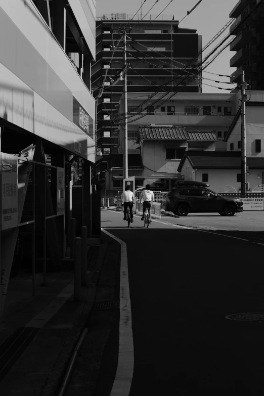 a black and white po of a man riding his bicycle in a town