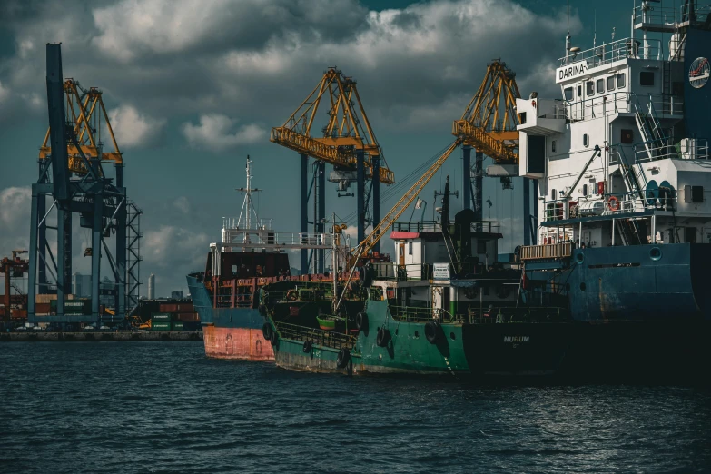 two large boats next to each other and cranes