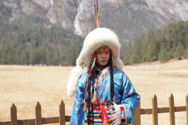 a girl is wearing a native american dress and hat