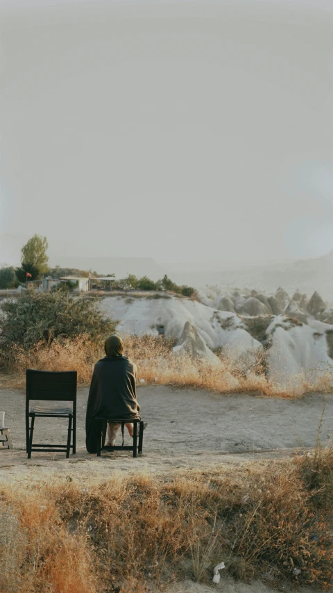 two people sitting on a bench in the desert