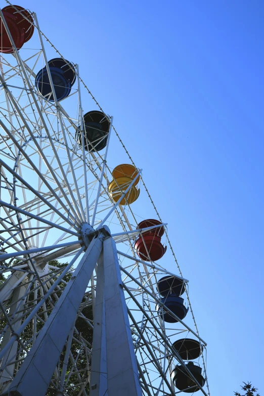 the ferris wheel is brightly colored against a clear blue sky