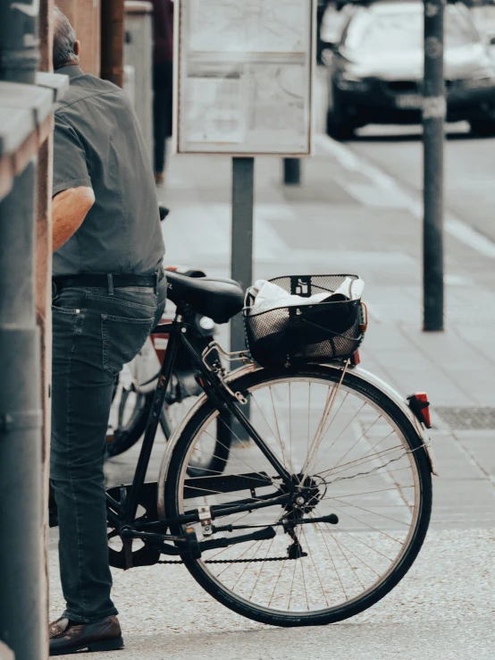 a man leaning on the wall next to his bike