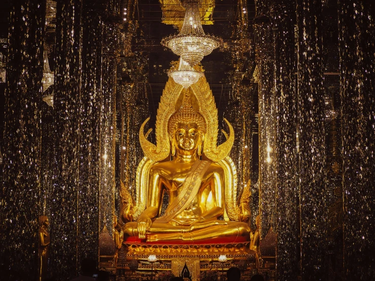 a golden buddha sitting in front of large lights