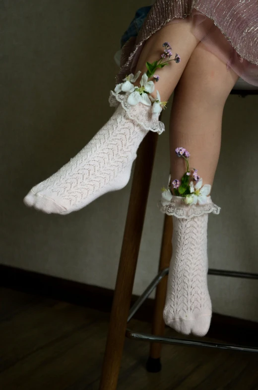 a woman is sitting on a chair with socks and flowers