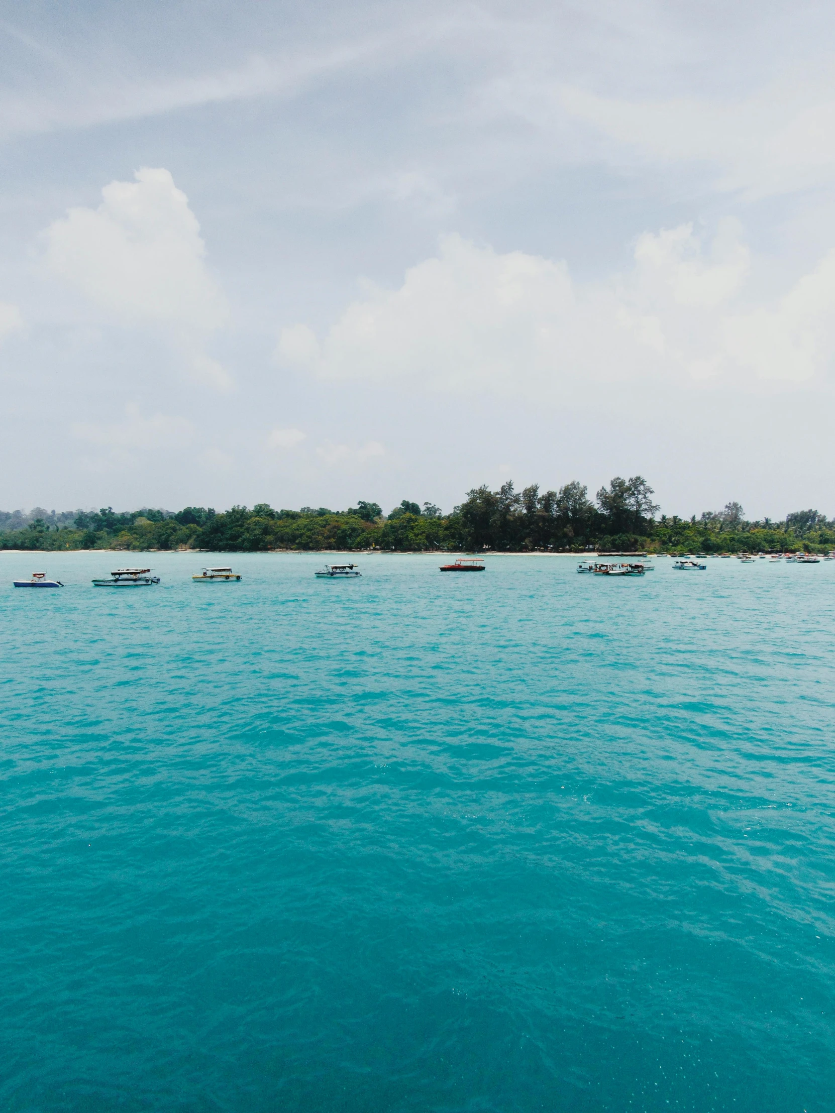 many boats are floating on the large body of water