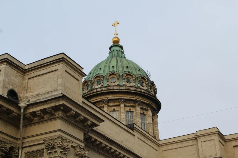 a tower with a green domed top and gold cross