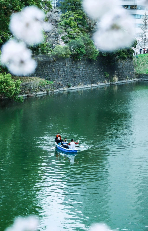 two people paddling in small boat on a river