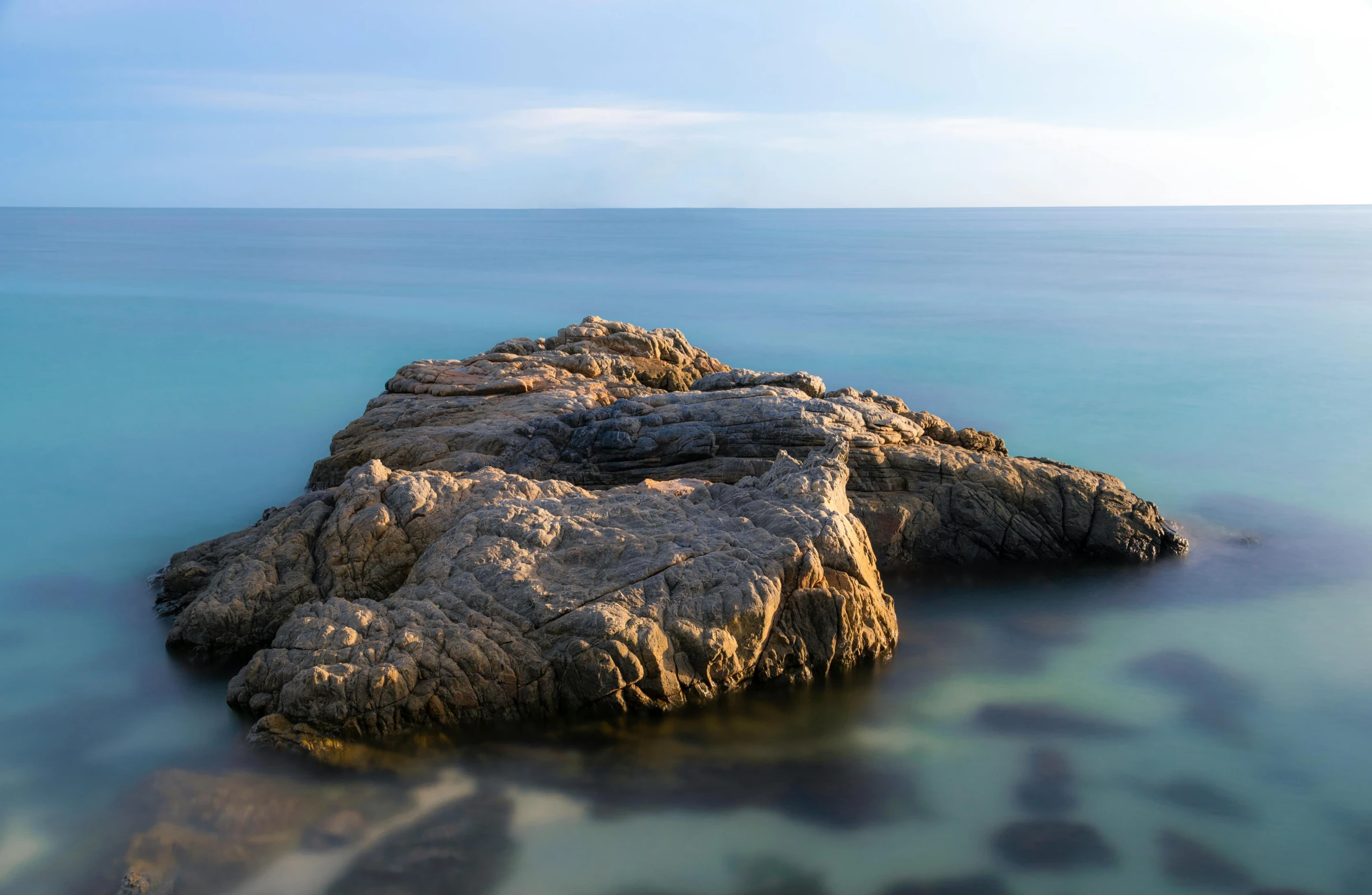 a big rock sticking out of some water